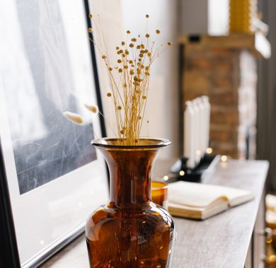 Brown glass vase with dried flowers in the interior of a modern Brown glass vase with dried flowers in the interior of a modern house