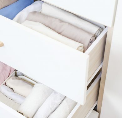 Clothes folded in a box in a dresser close-up, space organization concept. Clothes folded in a box in a dresser close up, space organization concept.