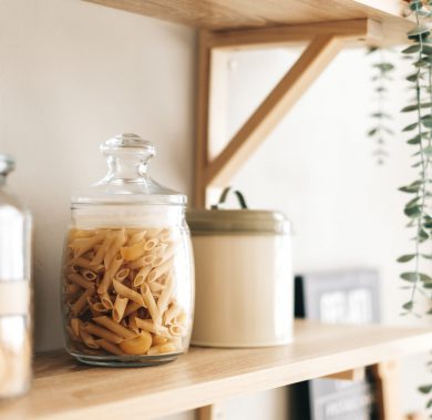 Grocery and kitchenware on the wooden shelves in modern bright kitchen. Grocery and kitchenware on the wooden shelves in modern bright kitchen.